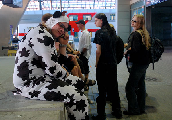 Man dressed as a cow, talking on cell phone, Helsinki train station