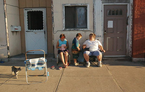 Family sitting outside their apartment, Jonesboro