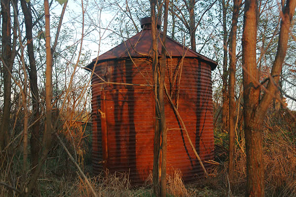 Rusted grain bin on abandoned farm